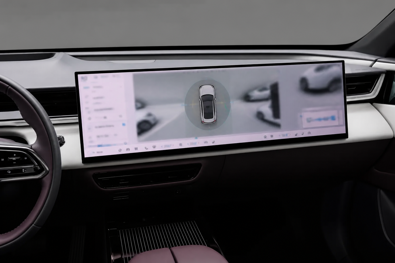 Escorzo de la pantalla central sobre la consola mostrando una vista cenital 360 grados del coche durante una maniobra.