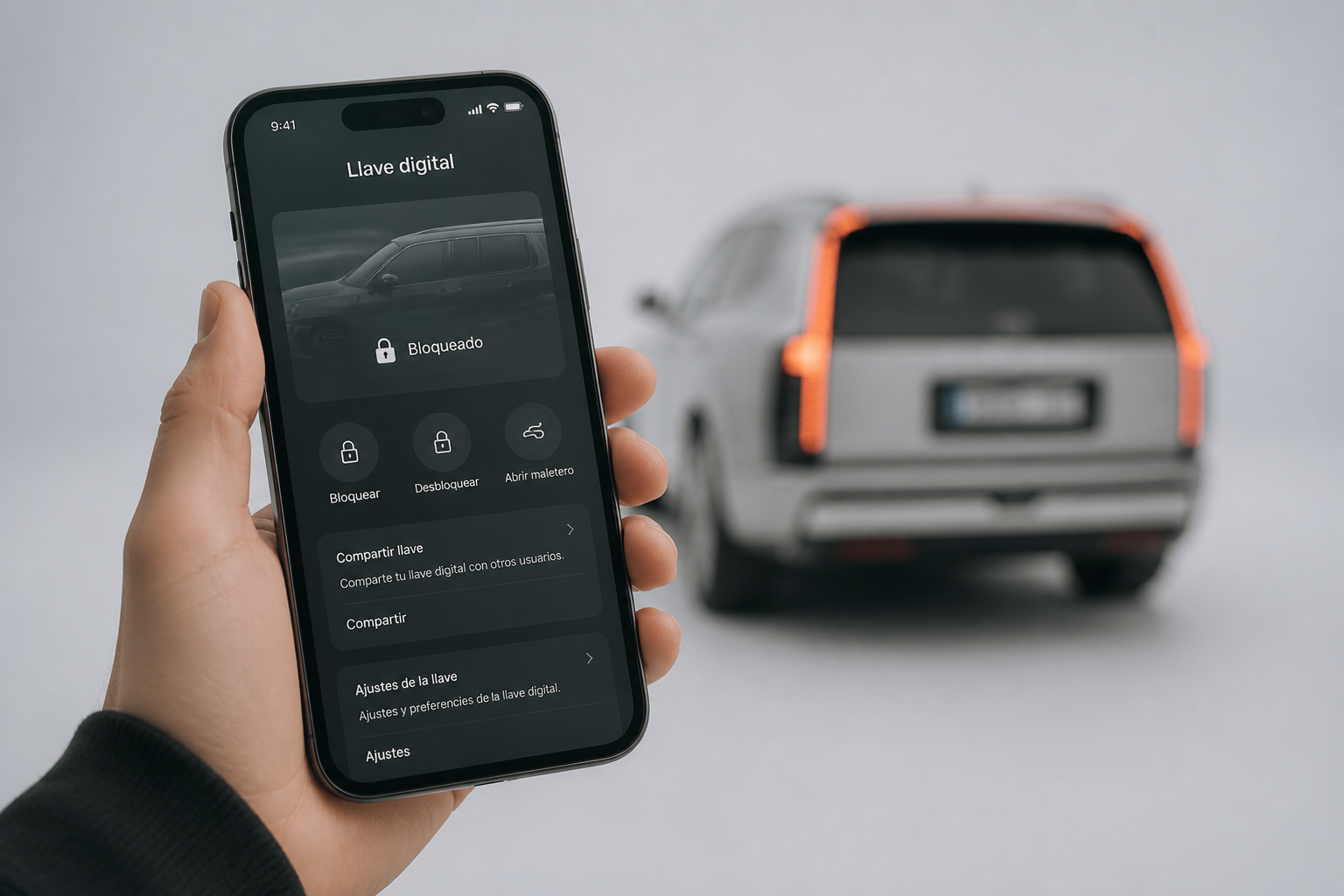 Smartphone en primer plano con interfaz de llave digital y la silueta del IONIQ 9 desenfocada al fondo